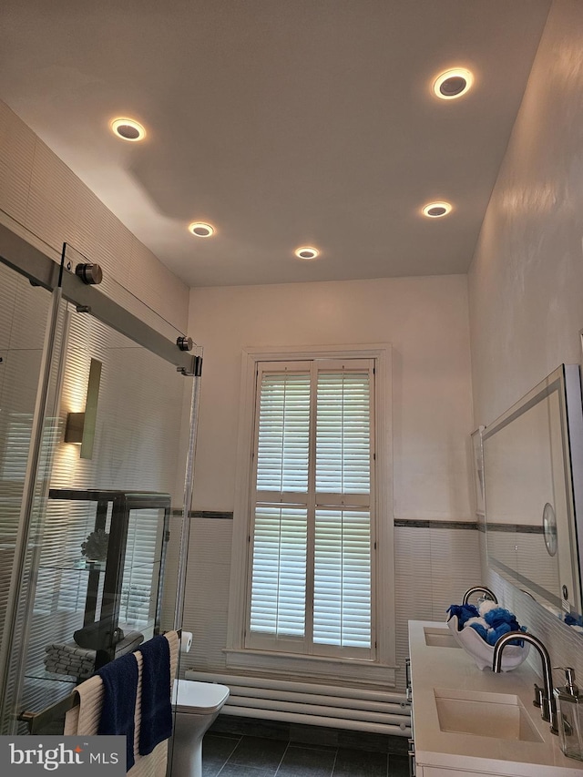 bathroom with tile floors, toilet, and double sink