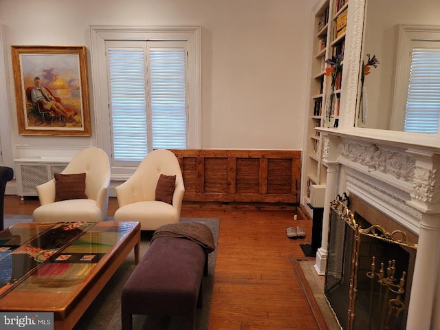 living room featuring a fireplace, dark hardwood / wood-style flooring, and built in shelves