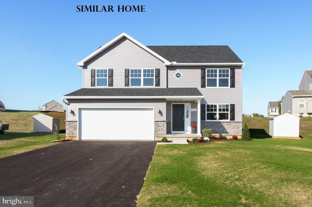 view of front of property featuring a front lawn and a garage