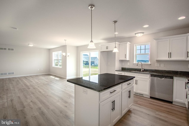 kitchen with white cabinetry, light hardwood / wood-style flooring, and stainless steel dishwasher