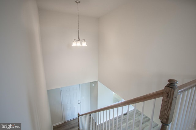 stairs with an inviting chandelier and hardwood / wood-style floors