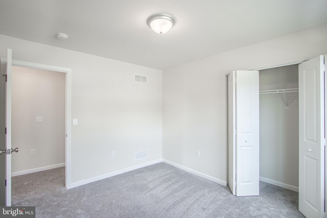 unfurnished bedroom with light carpet and a closet