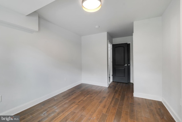 unfurnished room with dark wood-type flooring