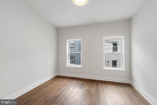 unfurnished room featuring hardwood / wood-style flooring