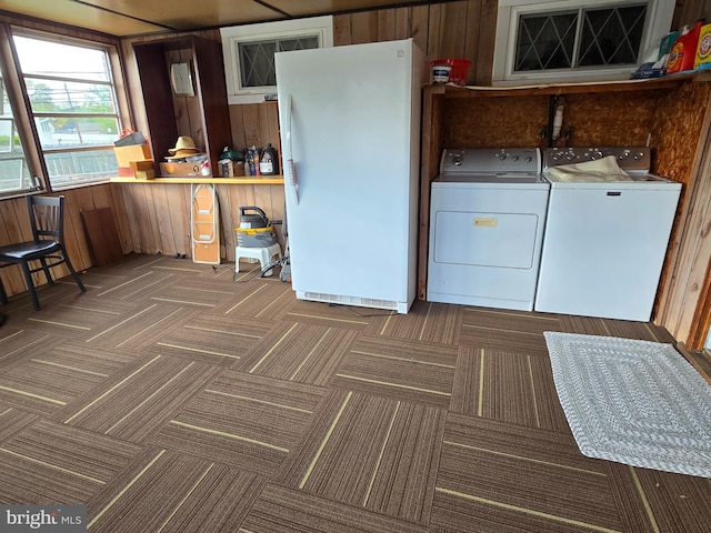 laundry area featuring independent washer and dryer, wood walls, and carpet floors