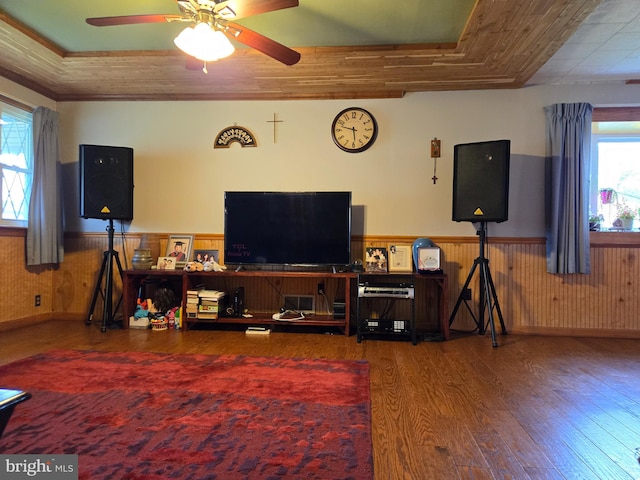 living room with hardwood / wood-style floors, a wealth of natural light, ceiling fan, and a tray ceiling