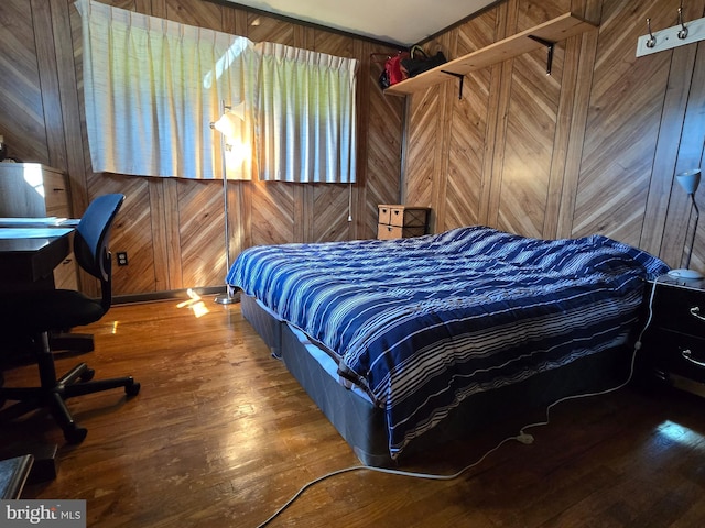 bedroom featuring hardwood / wood-style floors and wooden walls