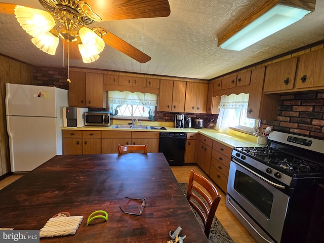 kitchen with ceiling fan, a wealth of natural light, stainless steel appliances, and sink