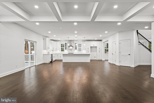 unfurnished living room featuring beam ceiling and dark hardwood / wood-style flooring