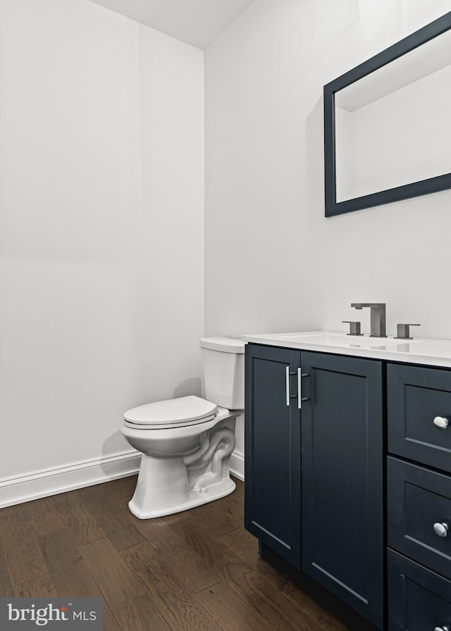 bathroom with hardwood / wood-style floors, vanity, and toilet