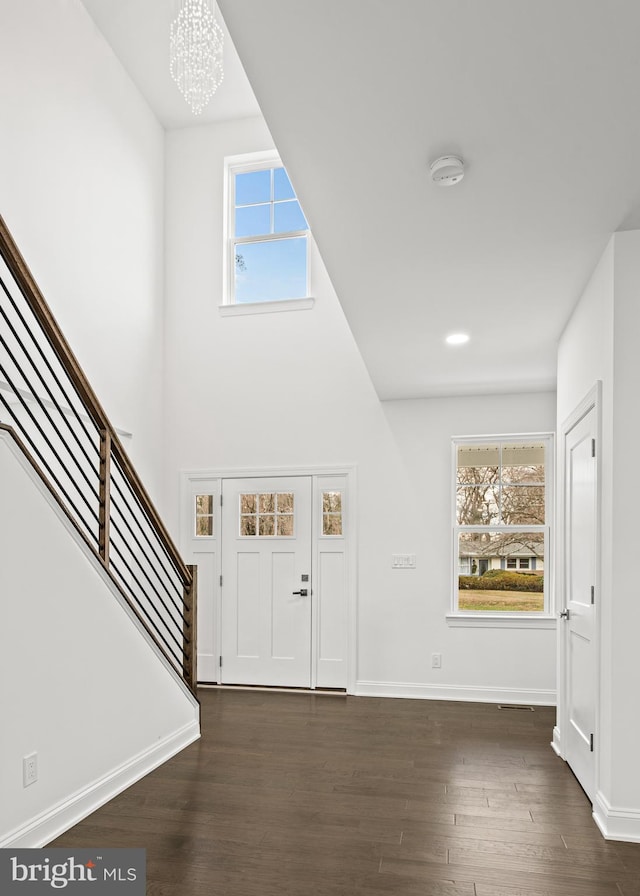 foyer entrance with dark hardwood / wood-style floors and a notable chandelier