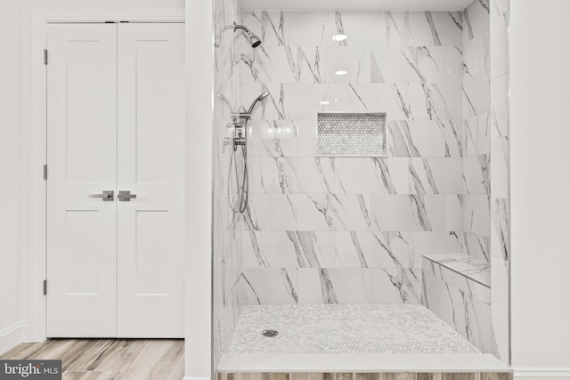 bathroom with hardwood / wood-style floors and tiled shower