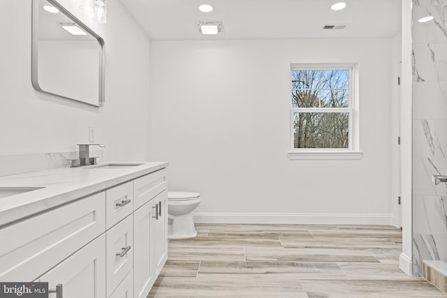 bathroom featuring vanity, hardwood / wood-style flooring, and toilet