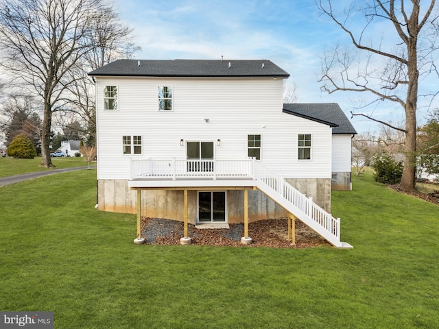 rear view of house featuring a lawn and a wooden deck