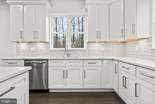 kitchen featuring dark wood-type flooring, sink, stainless steel dishwasher, decorative backsplash, and white cabinetry