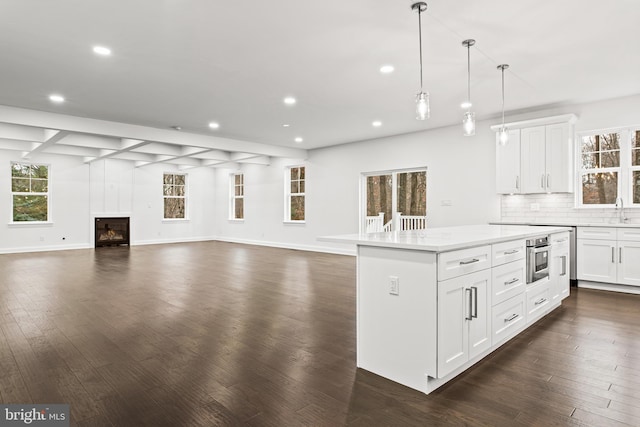 kitchen with decorative light fixtures, white cabinetry, and dark wood-type flooring