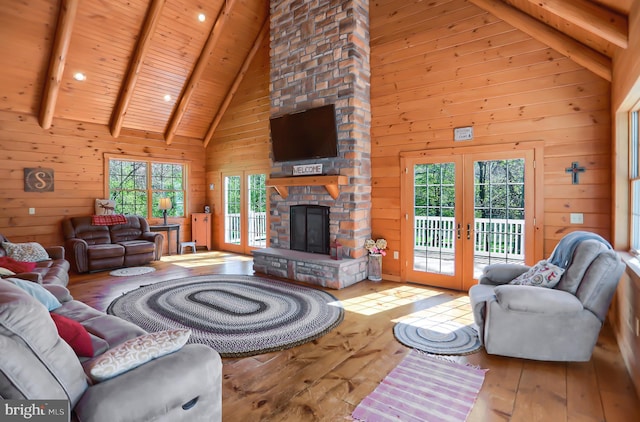 living room featuring wood ceiling, wood walls, french doors, high vaulted ceiling, and beam ceiling