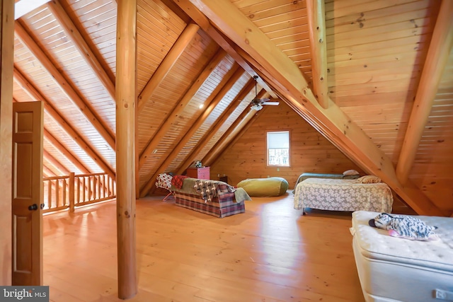 bedroom featuring hardwood / wood-style flooring, wooden ceiling, wooden walls, and vaulted ceiling with beams