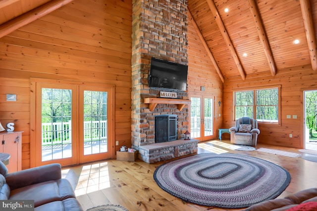 living room featuring high vaulted ceiling, wooden ceiling, and wooden walls