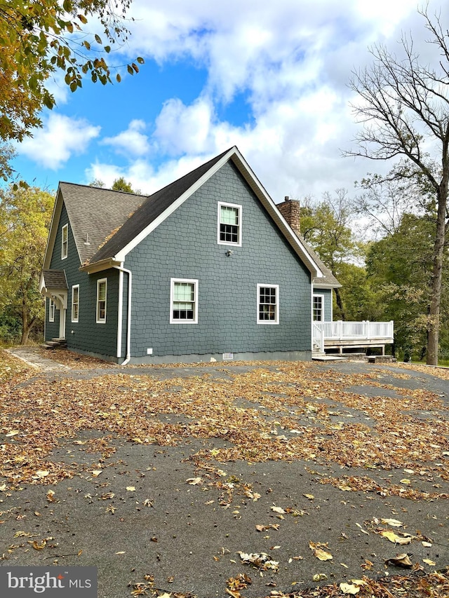 view of property exterior with a wooden deck