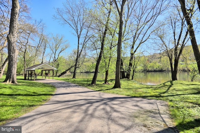 surrounding community featuring a water view and a lawn