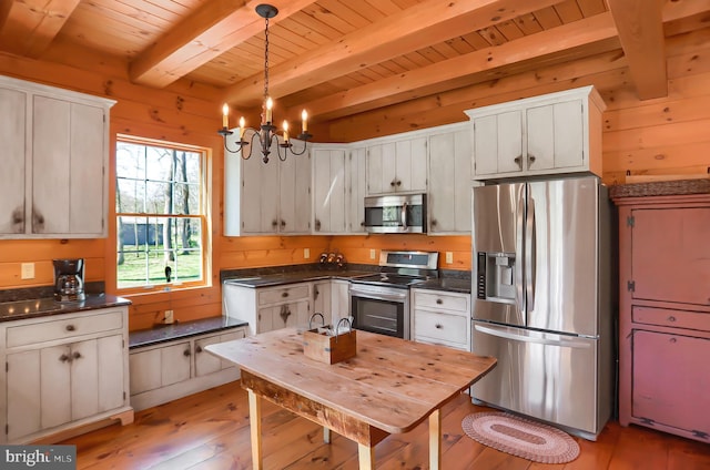 kitchen featuring a notable chandelier, white cabinetry, hanging light fixtures, light wood-type flooring, and appliances with stainless steel finishes