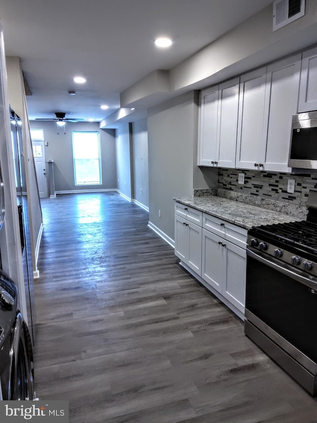 kitchen featuring light stone countertops, dark hardwood / wood-style flooring, white cabinets, and stainless steel appliances