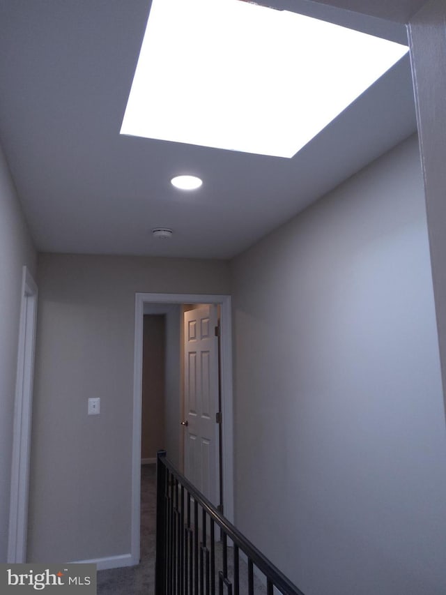 hall featuring carpet flooring and a skylight