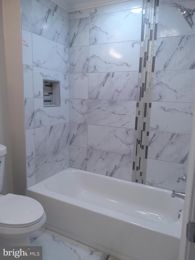 bathroom with toilet and tiled shower / bath