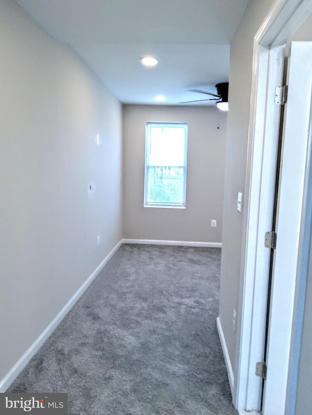 unfurnished room featuring dark colored carpet and ceiling fan