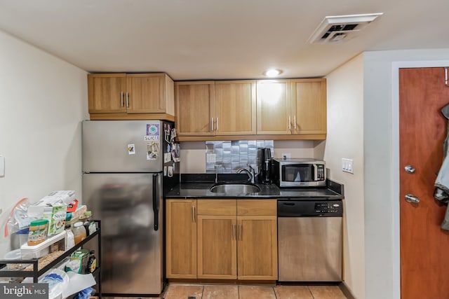 kitchen featuring sink, appliances with stainless steel finishes, tasteful backsplash, and light tile floors