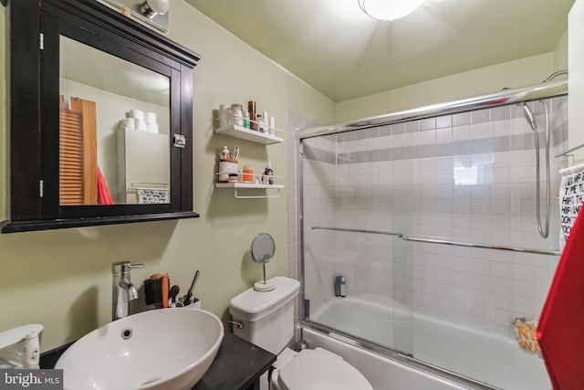 full bathroom with shower / bath combination with glass door, toilet, and sink