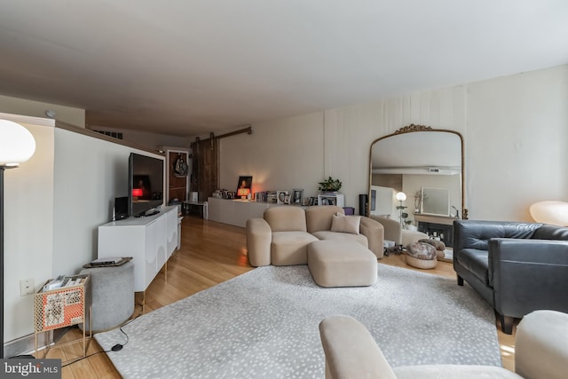 living room featuring light hardwood / wood-style flooring and a barn door