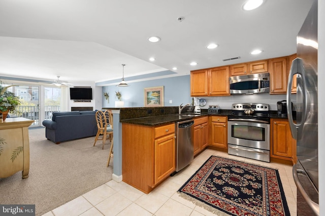 kitchen featuring ceiling fan, kitchen peninsula, pendant lighting, light colored carpet, and appliances with stainless steel finishes