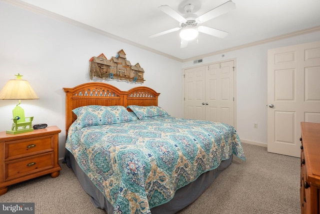 carpeted bedroom with a closet, ornamental molding, and ceiling fan