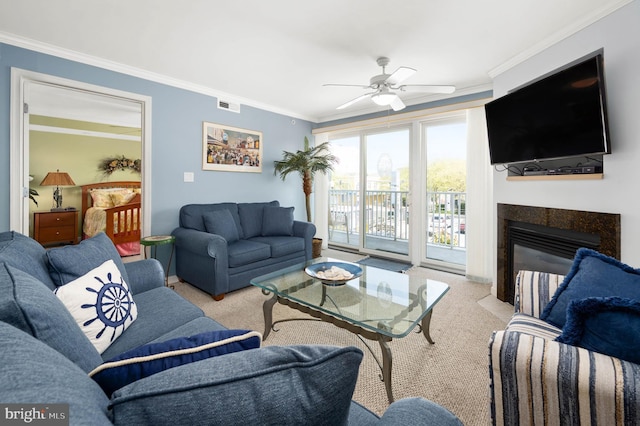 carpeted living room featuring ceiling fan and ornamental molding