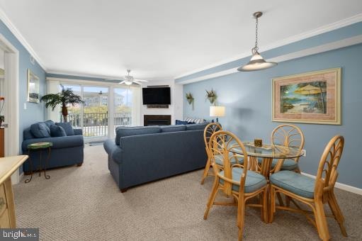 dining room featuring light colored carpet, ceiling fan, and crown molding