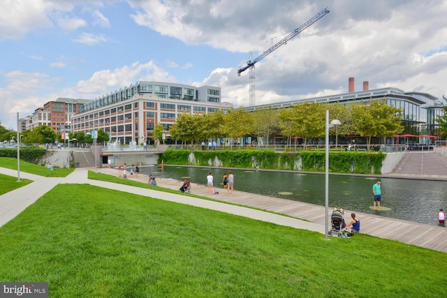 view of property's community with a water view and a lawn