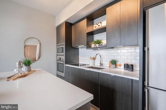 kitchen with appliances with stainless steel finishes, backsplash, and sink