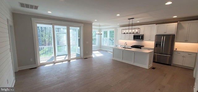 kitchen with plenty of natural light, wood-type flooring, and appliances with stainless steel finishes