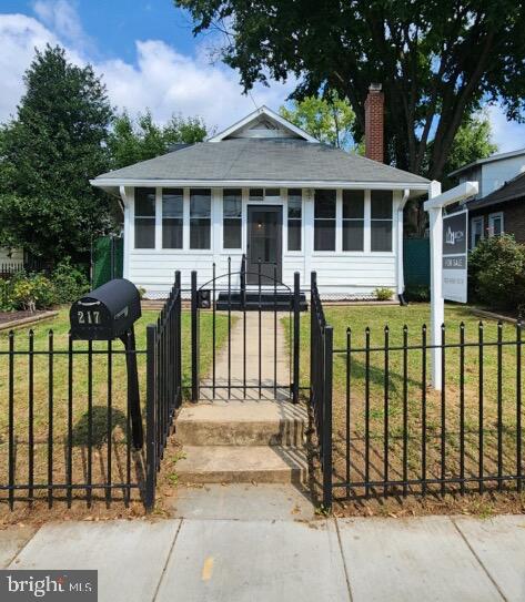 view of front of home featuring a front yard and a sunroom