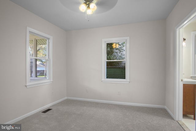 spare room featuring light carpet and ceiling fan