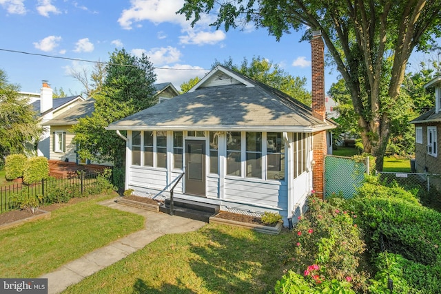 bungalow-style home featuring a sunroom and a front yard