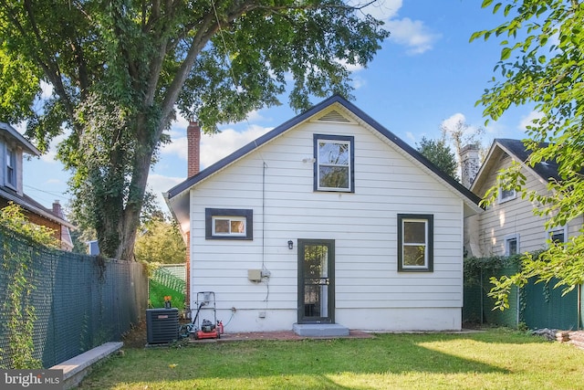 rear view of house with a yard and central AC unit