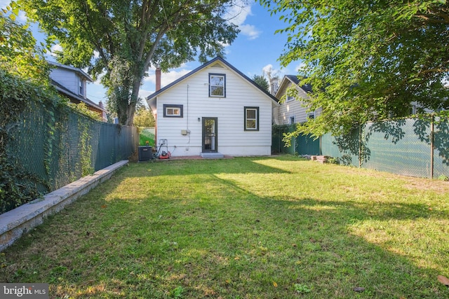 rear view of house featuring a yard and central air condition unit