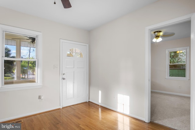 carpeted foyer entrance with ceiling fan