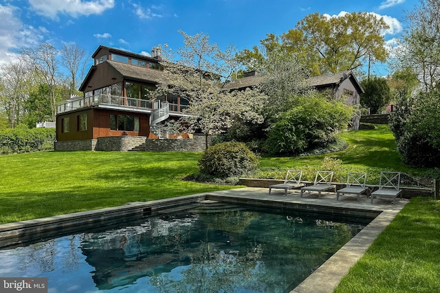 back of property with a patio area, a balcony, and a lawn