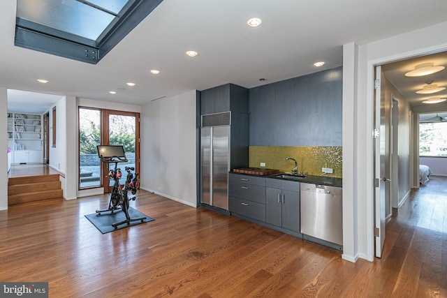 interior space with wood-type flooring, sink, stainless steel appliances, and a wealth of natural light