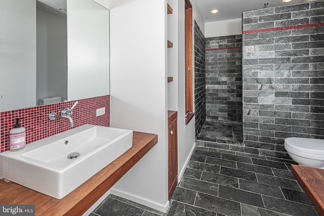 bathroom featuring tile floors, tile walls, large vanity, tasteful backsplash, and toilet