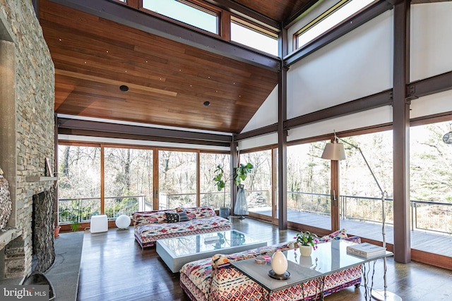 sunroom featuring lofted ceiling, plenty of natural light, wooden ceiling, and a fireplace